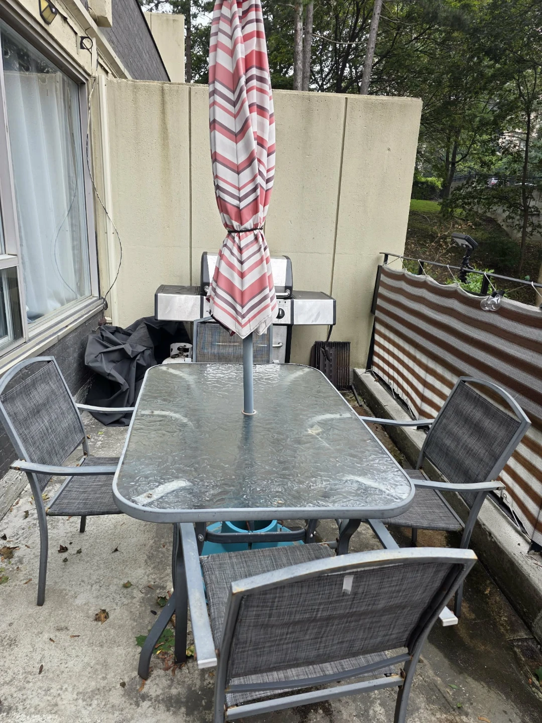 Glass patio table with 4 chairs and umbrella