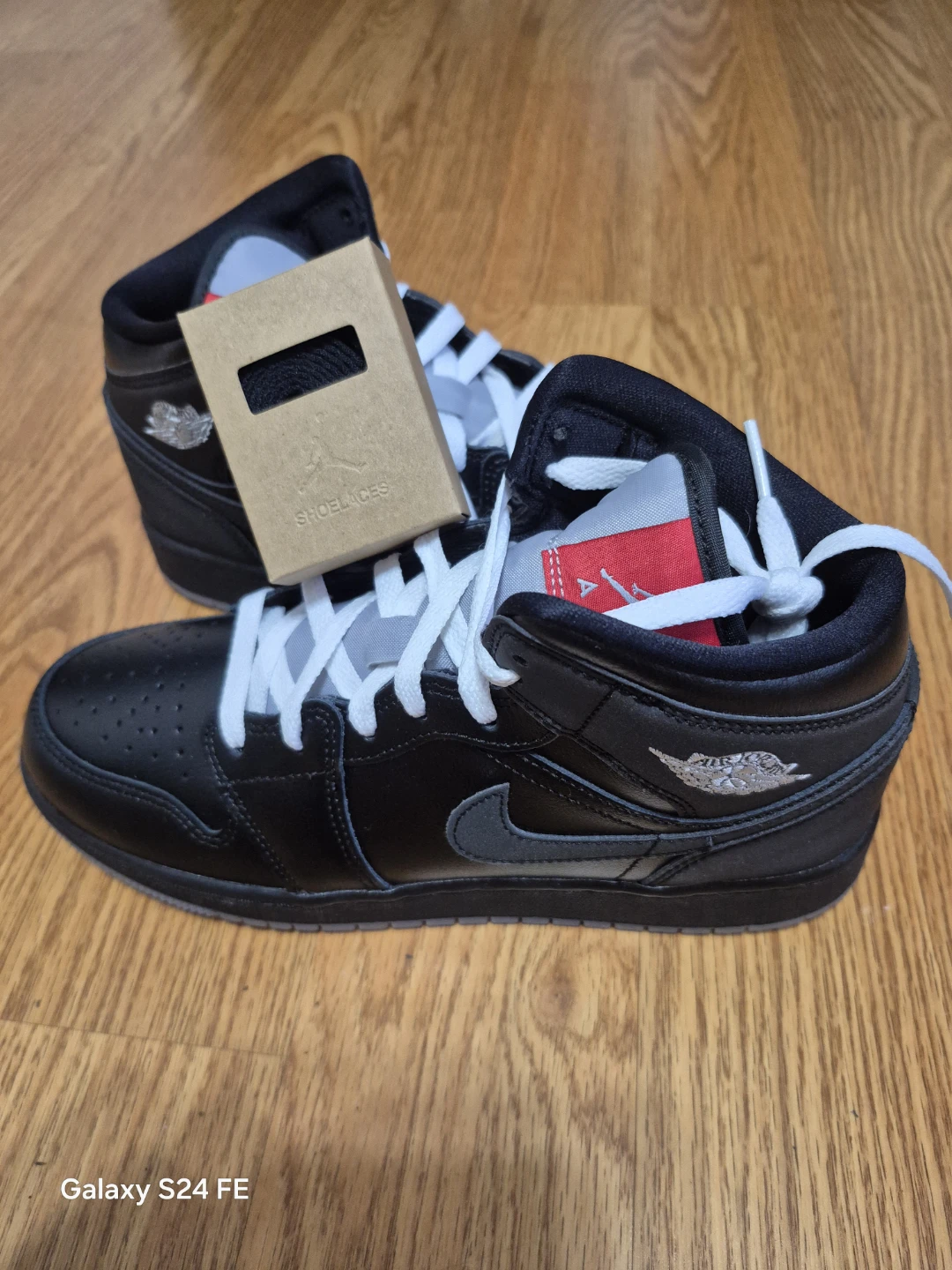 These are authentic Air Jordan 1 Mid sneakers in a black and red - photo 2