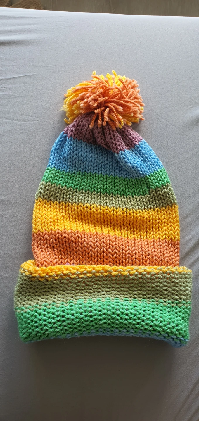 Hand-knitted multicoloured striped pom-pom hat