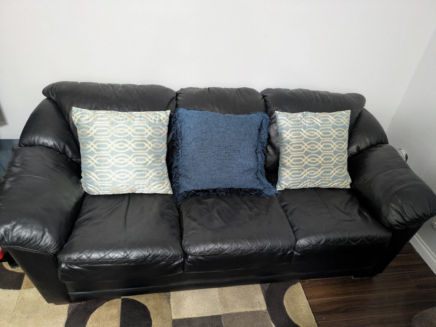 Black leather three-seater sofa