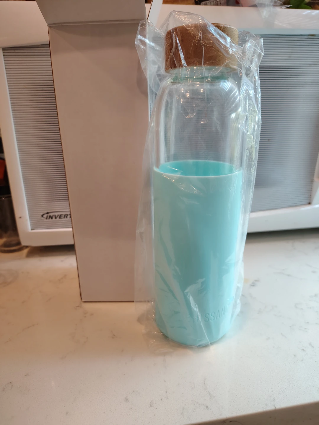 Biossance glass Water Bottle with Blue Silicone Sleeve