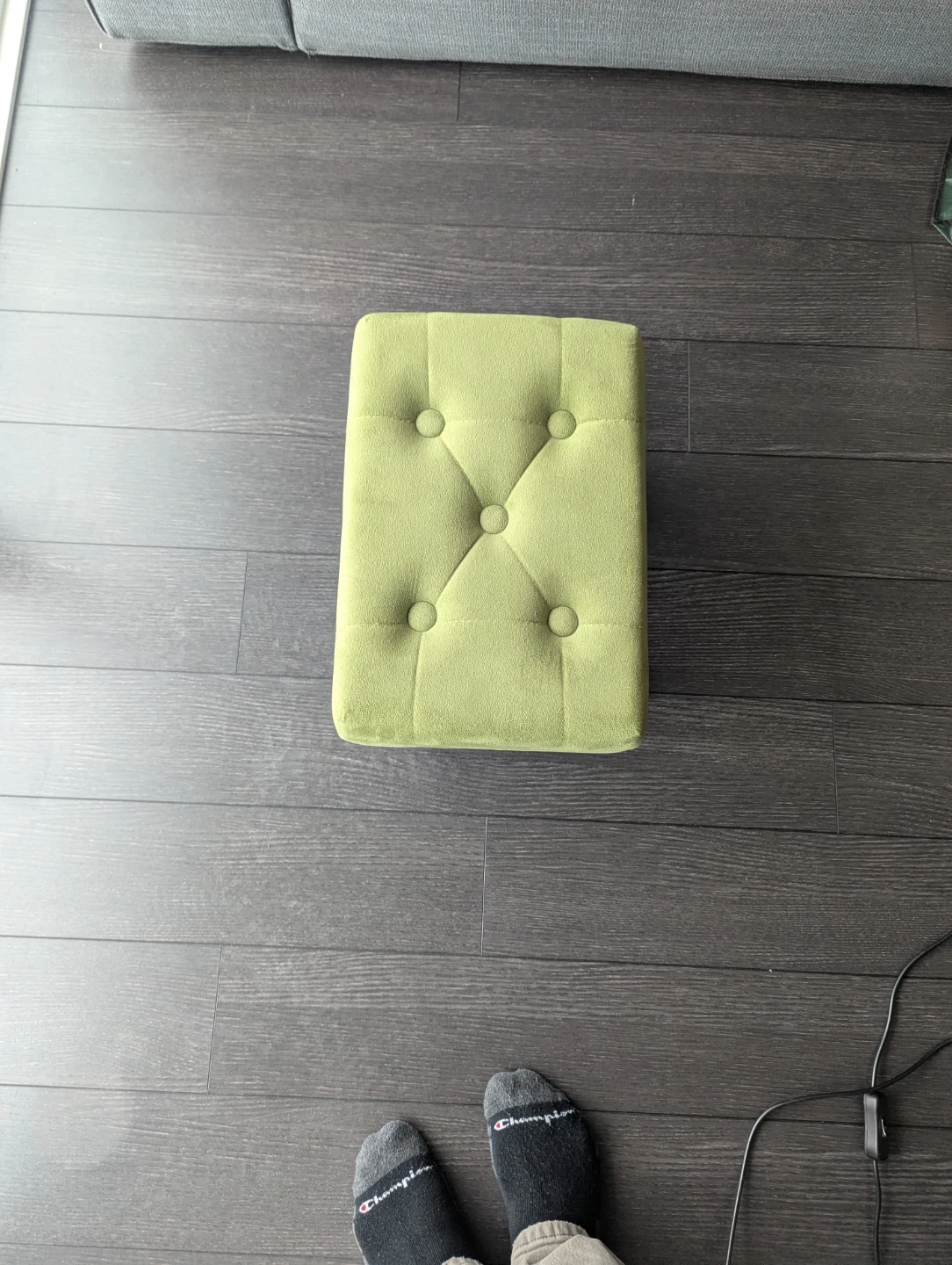 Green button-tufted fabric footstool