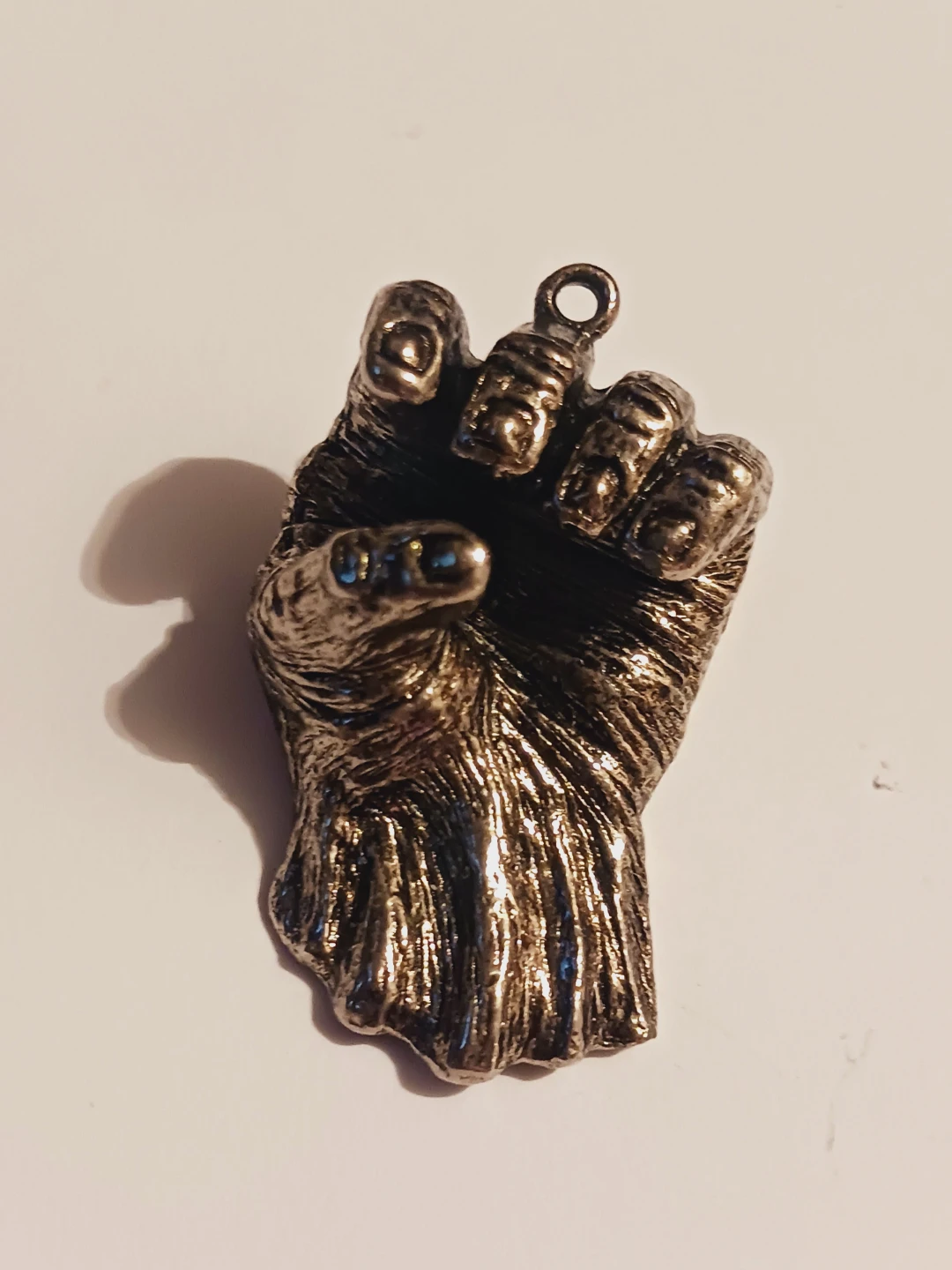 Beautiful detailed metallic silver tone fist pendant