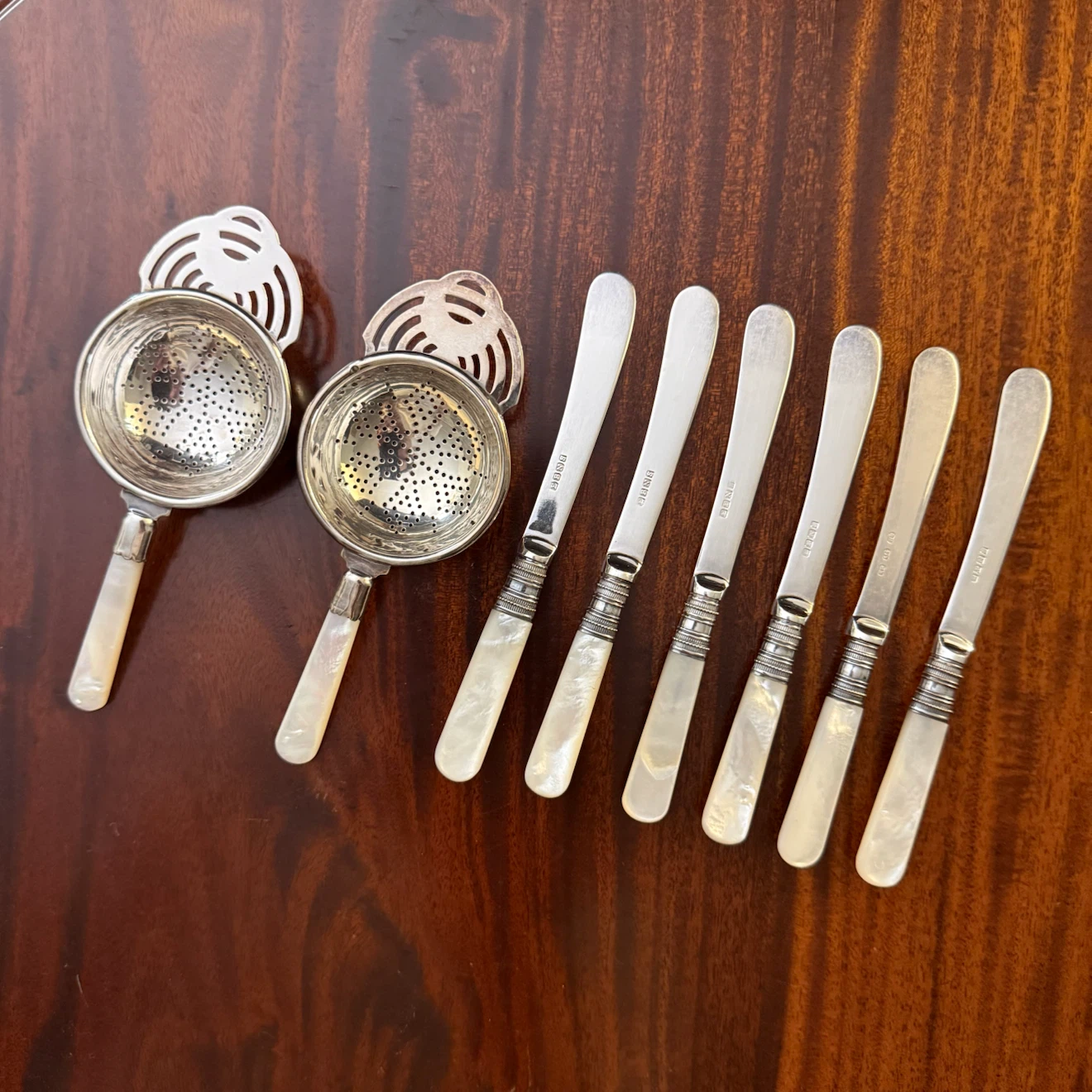 Mother of pearl handle butter knives and tea strainers