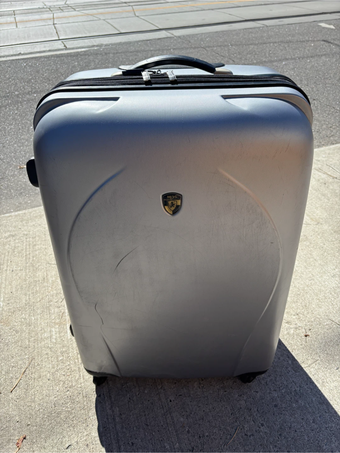 Large check in Heys silver hard-shell suitcase