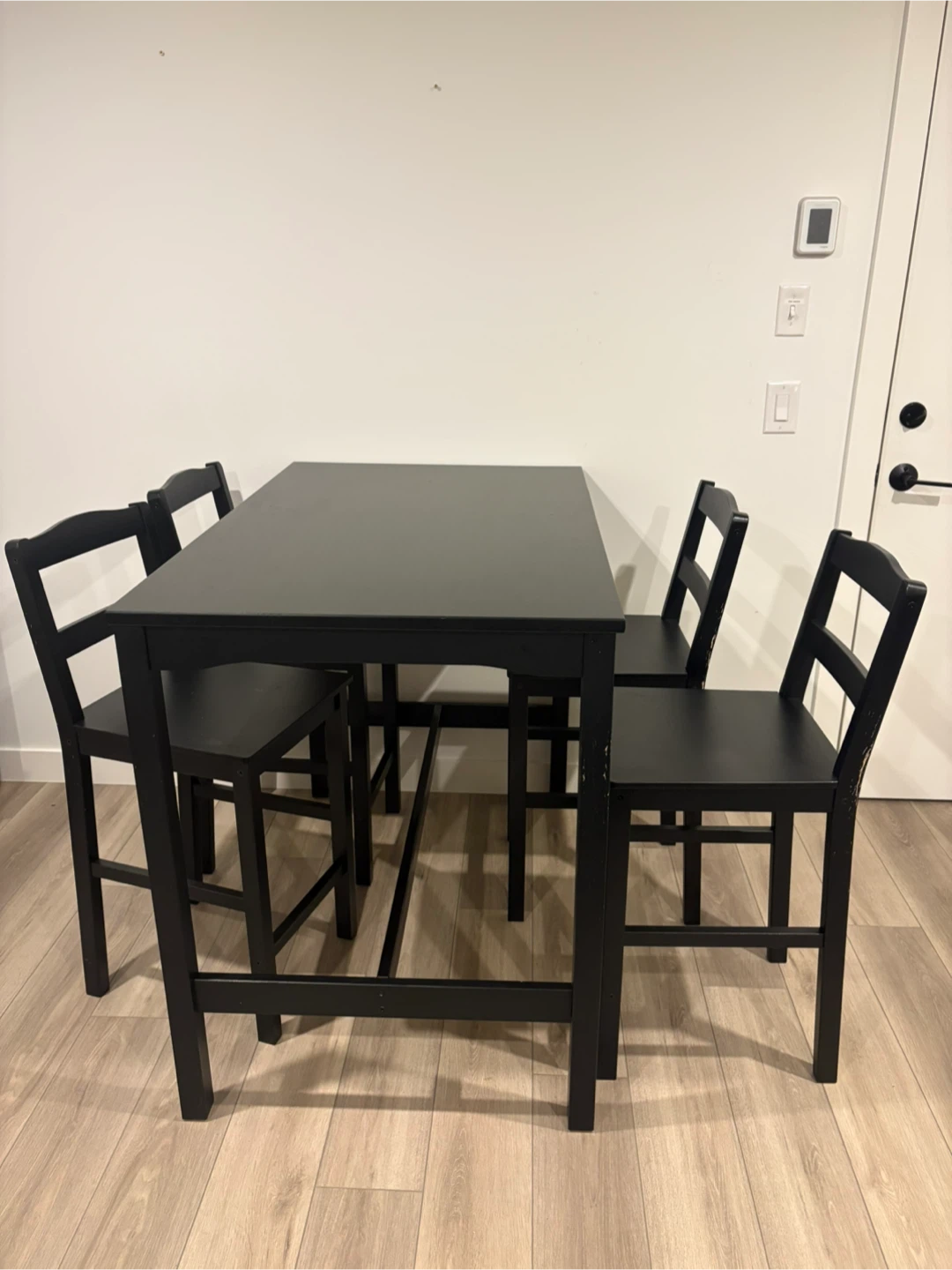 Black Ikea bar height table with 4 chairs.