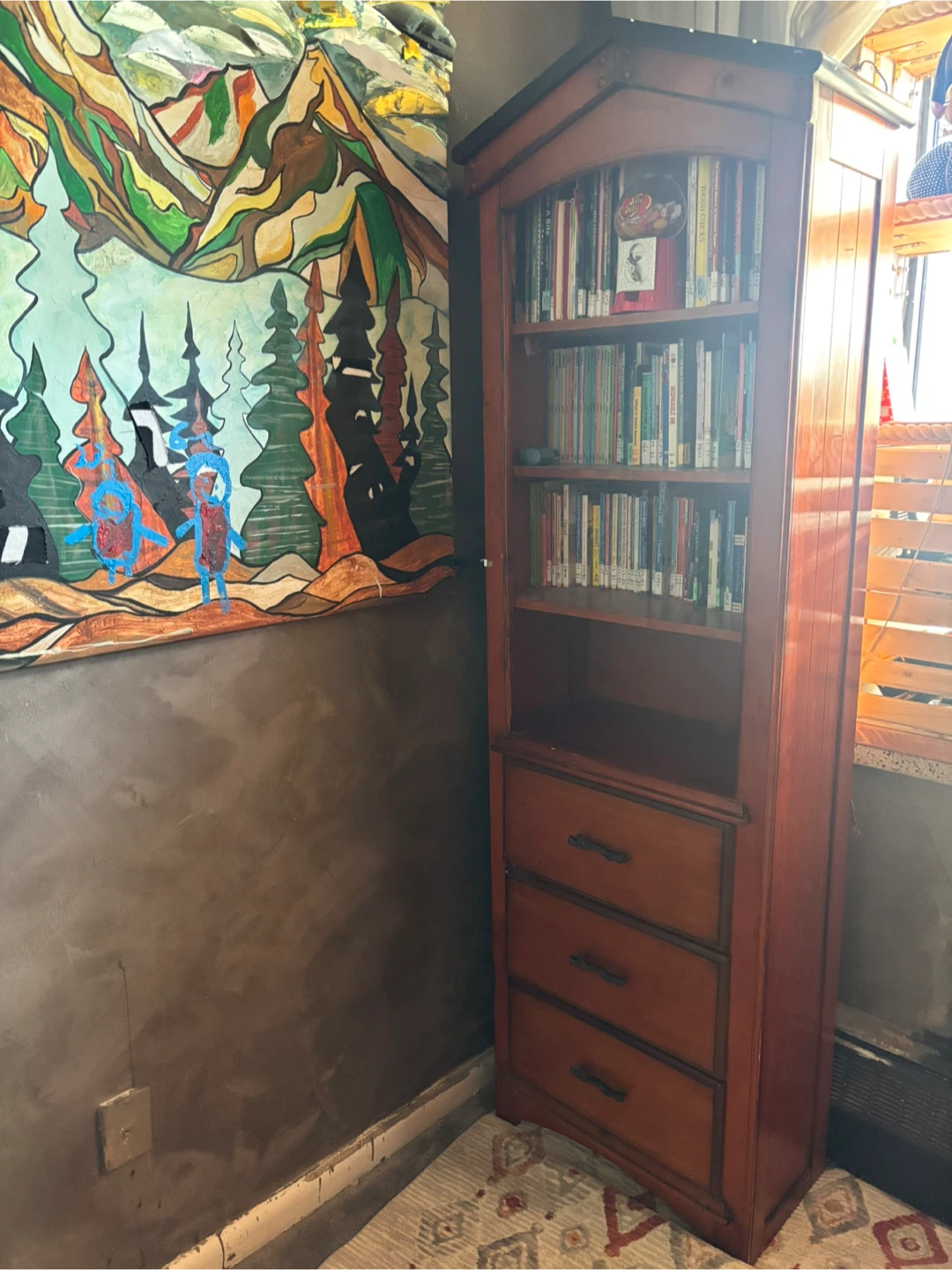 Tall wooden bookshelf with three drawers