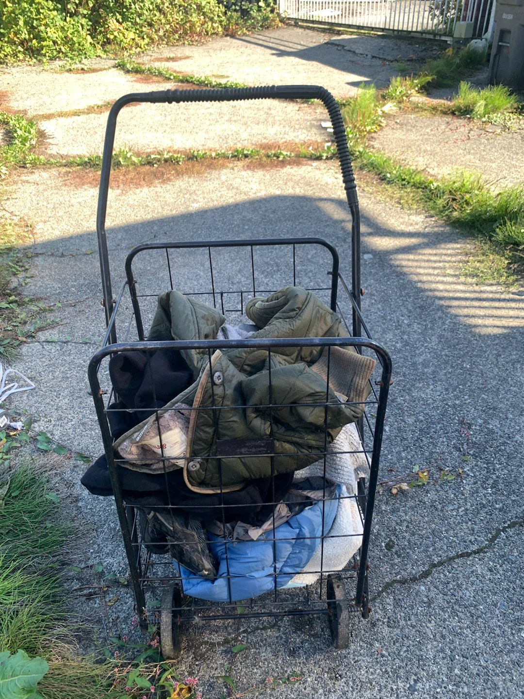 Metal shopping cart and assorted clothing bundle