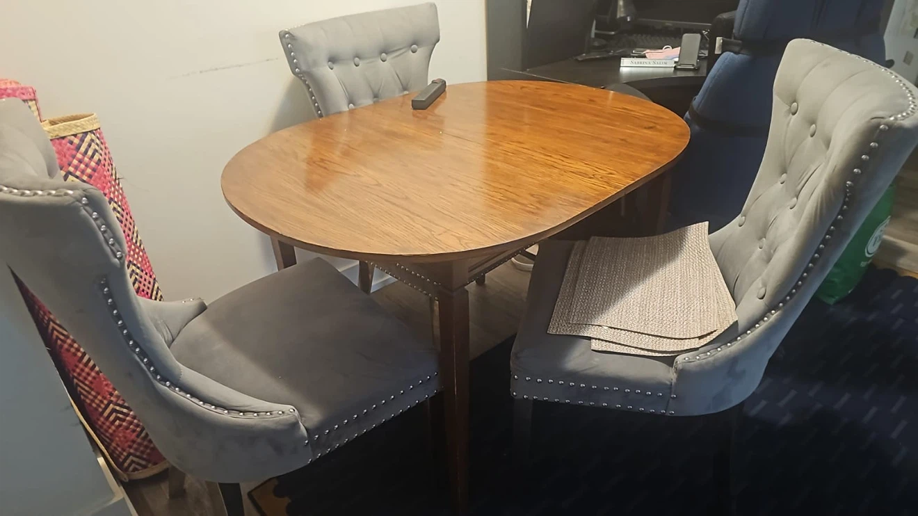 Oval Wood Dining Table with Three Grey Tufted Chairs