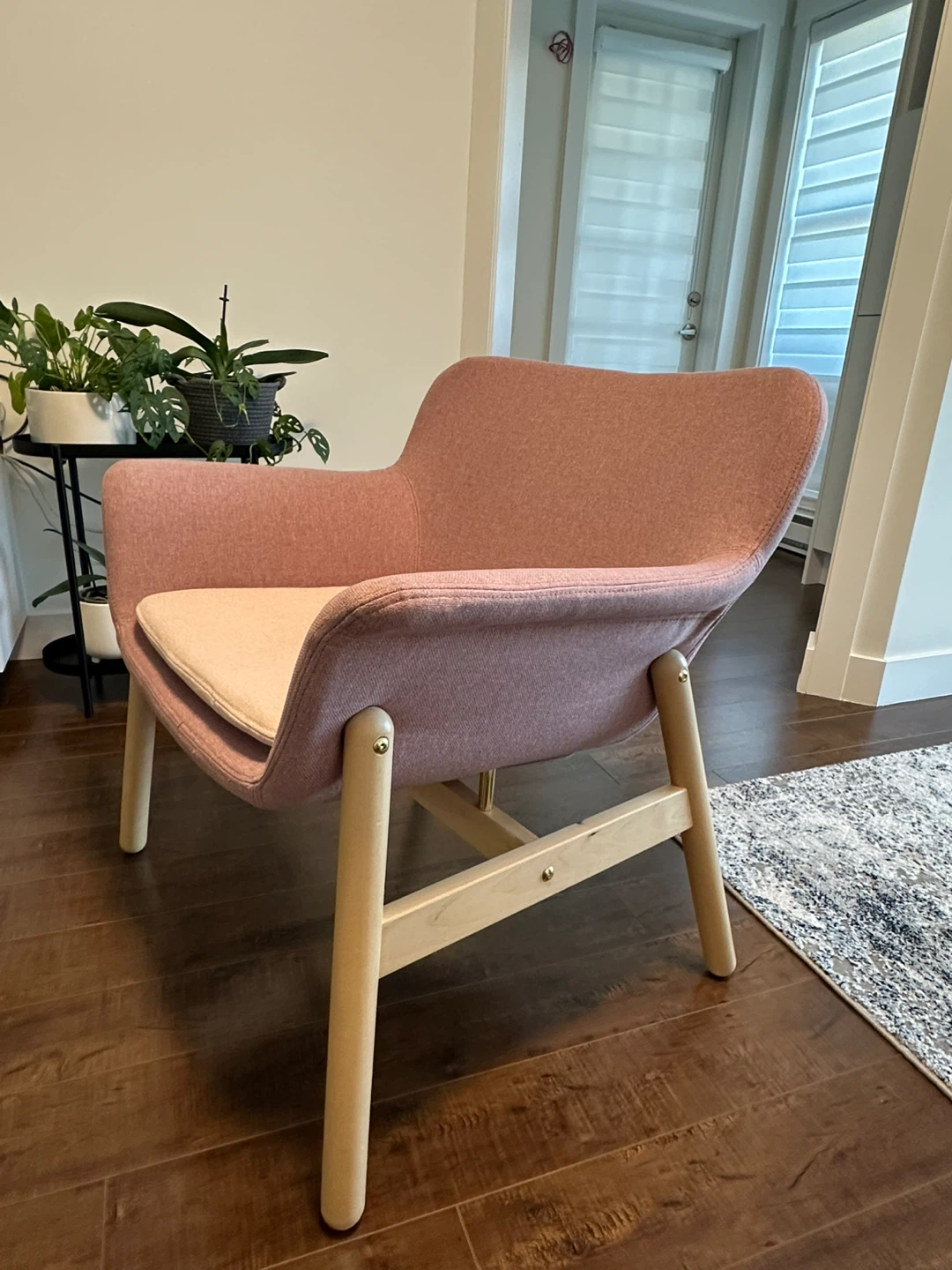 Pink fabric accent chair with light wood legs