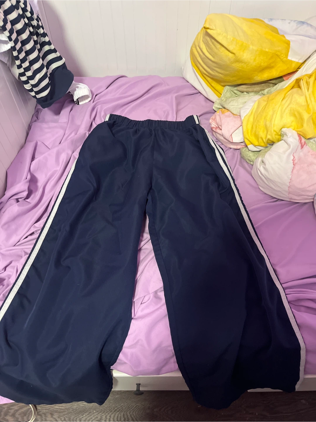Navy blue track pants with white side stripes