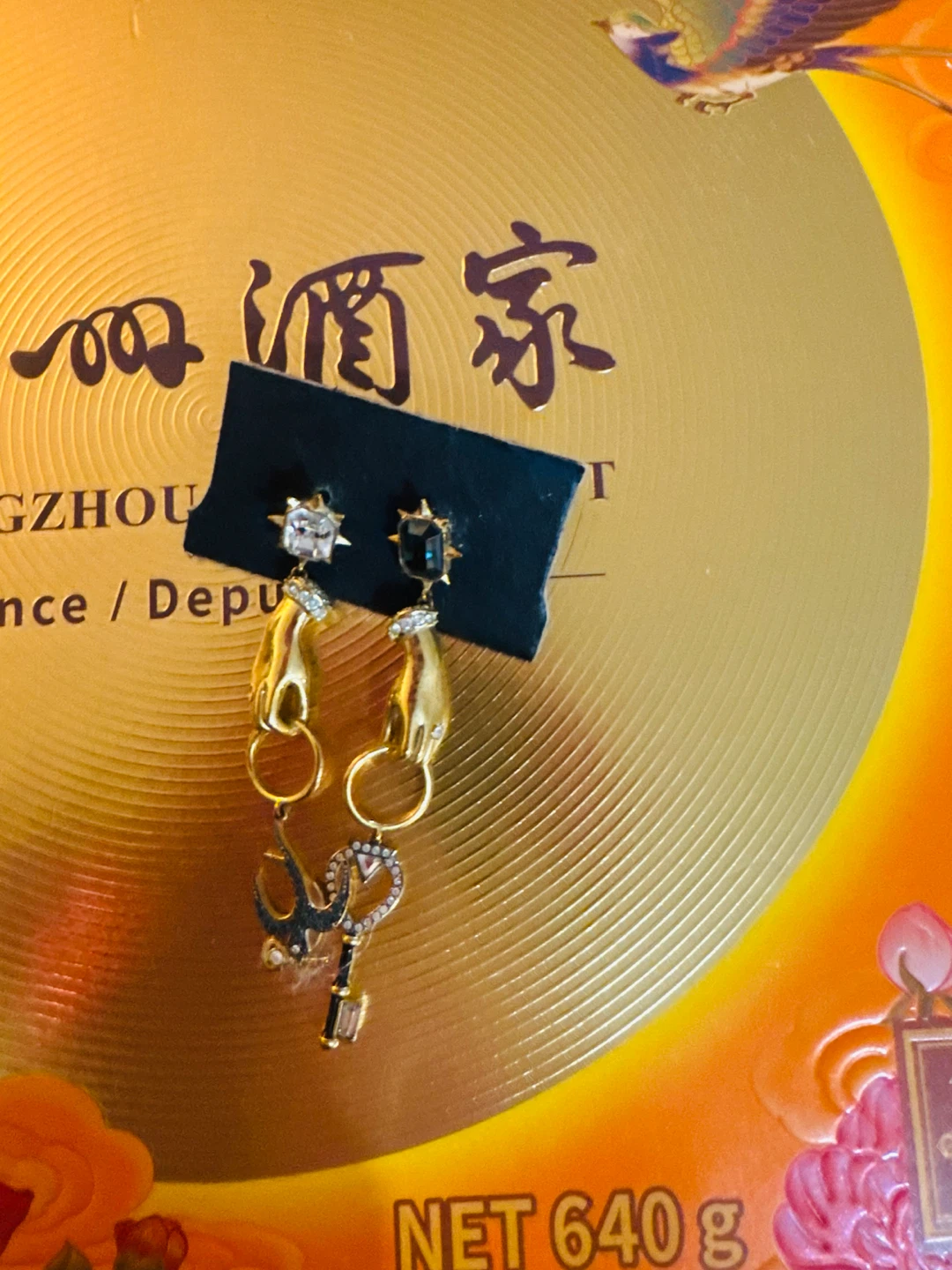 Gold-tone hand and charm dangle earrings