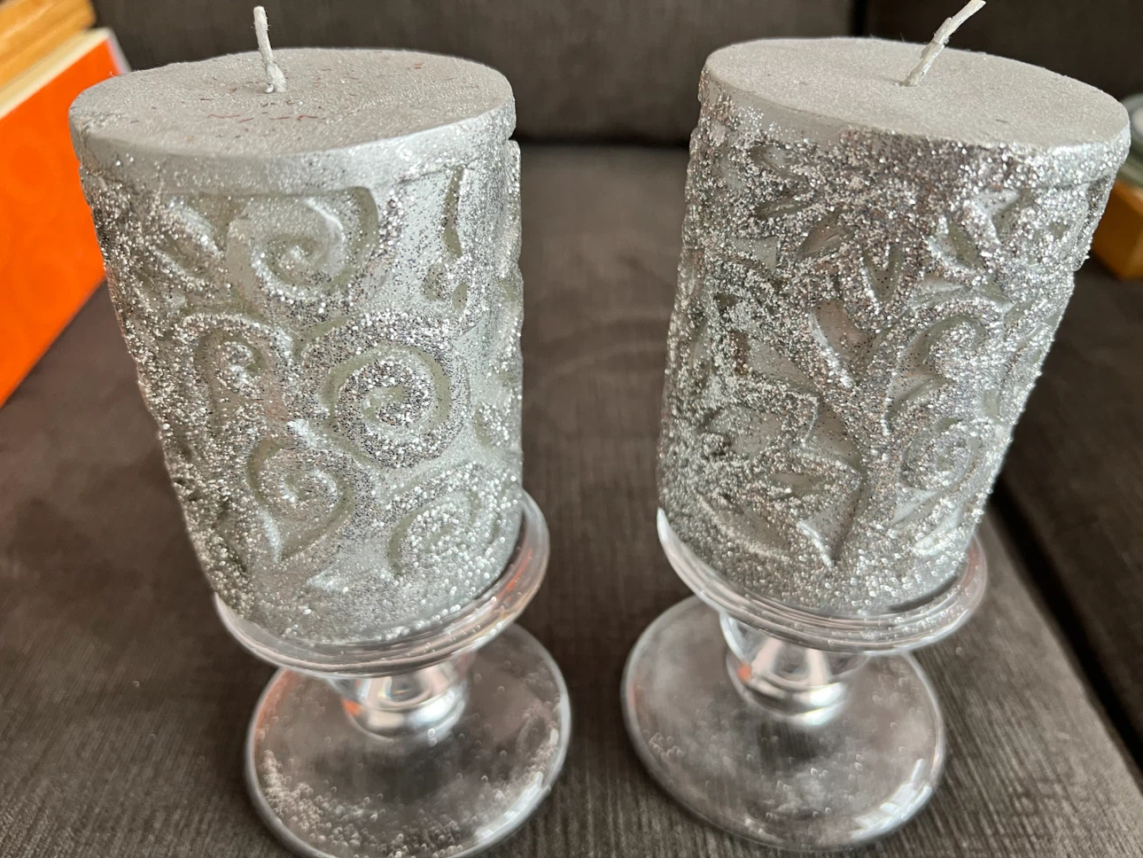 Two silver glitter candles with glass holders