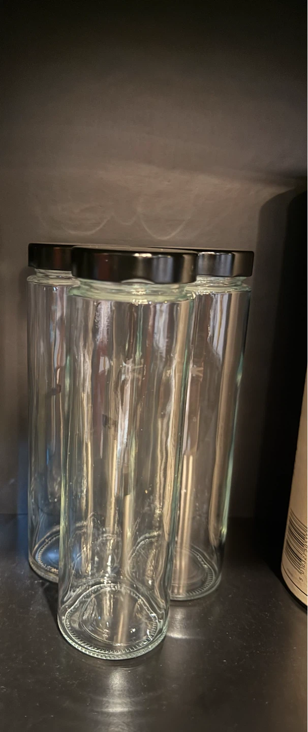 Three Tall Clear Glass Jars with Black Lids