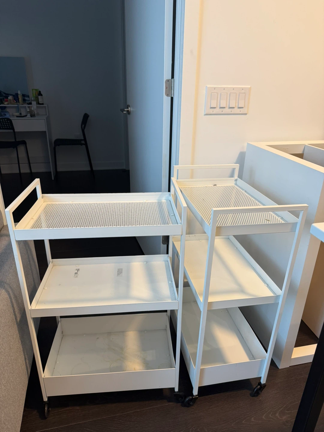 Two IKEA white metal utility carts