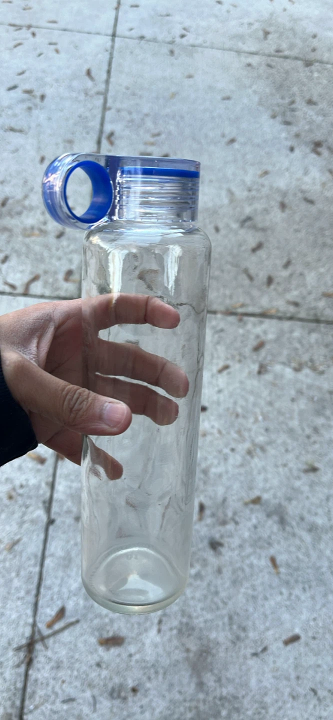 Clear glass water bottle with blue carry loop