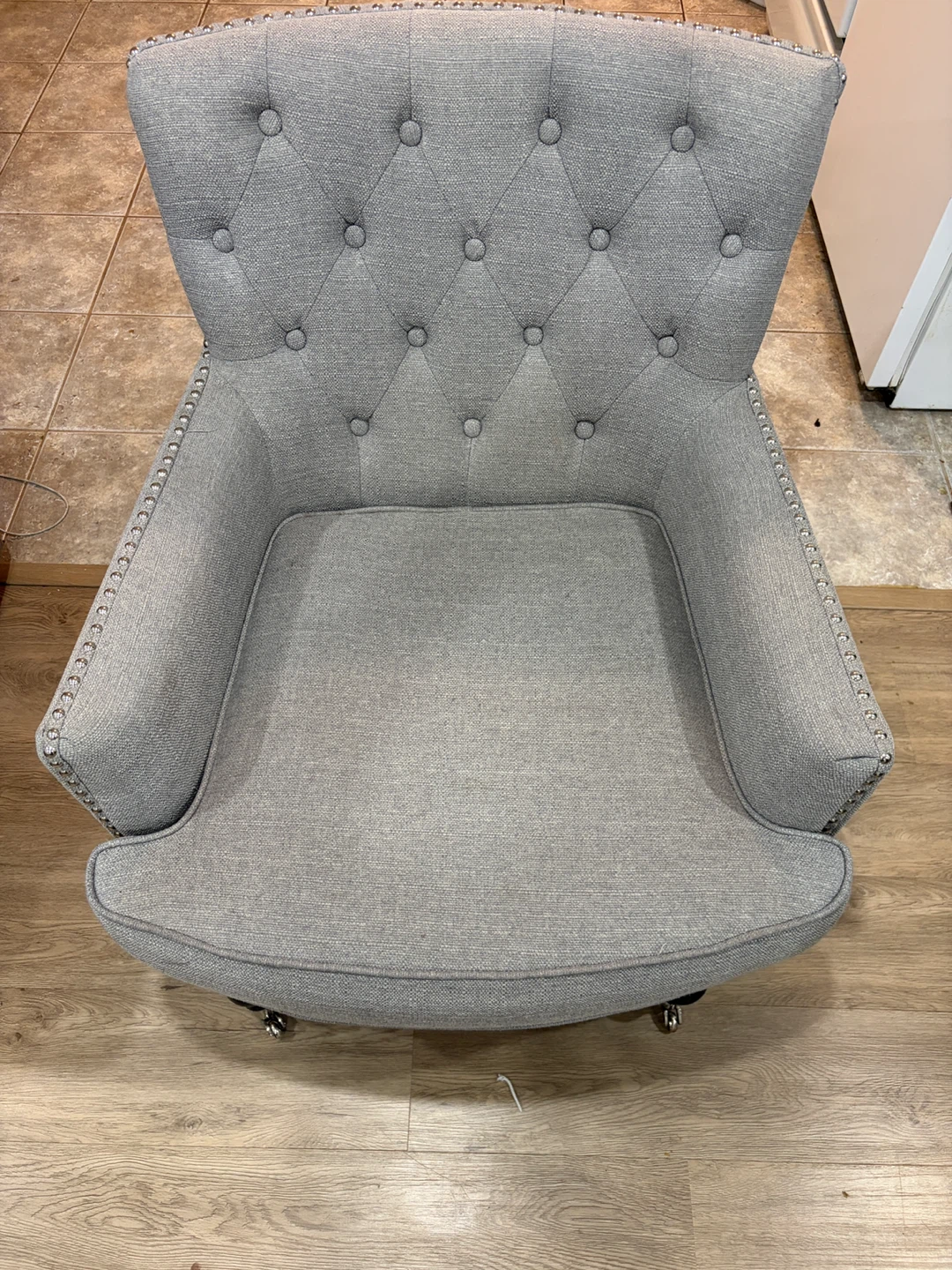Grey tufted accent chair with casters