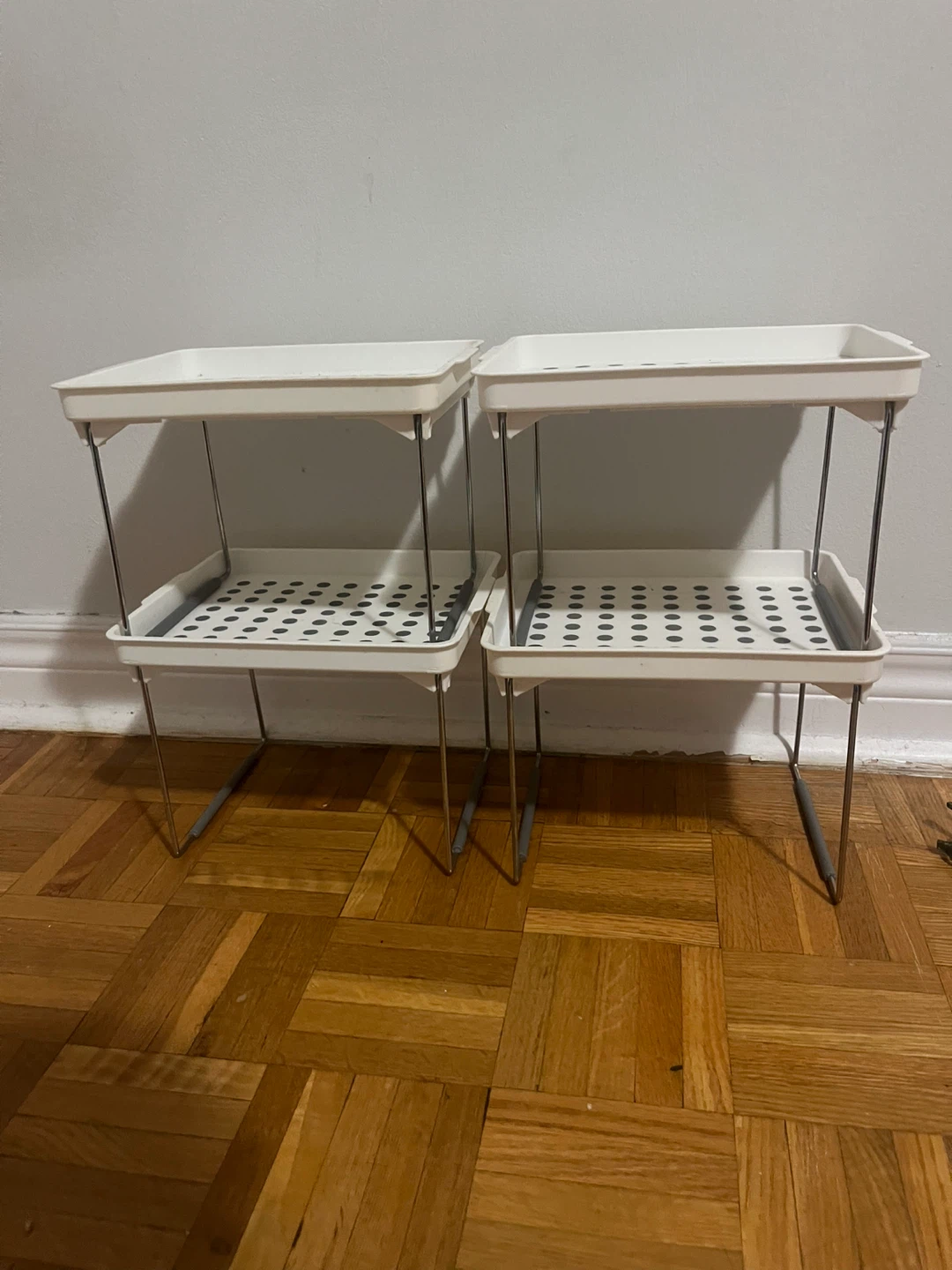 Four stackable white storage shelves