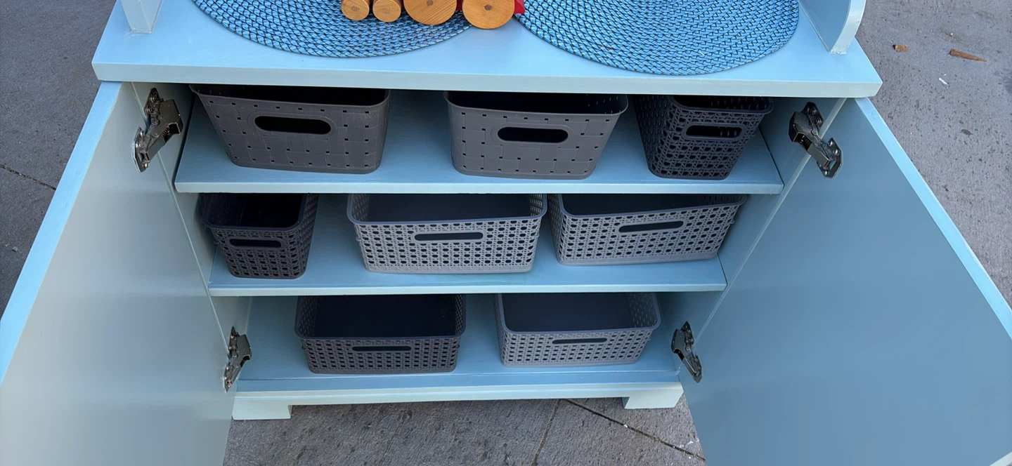 Light blue wooden dresser with storage baskets