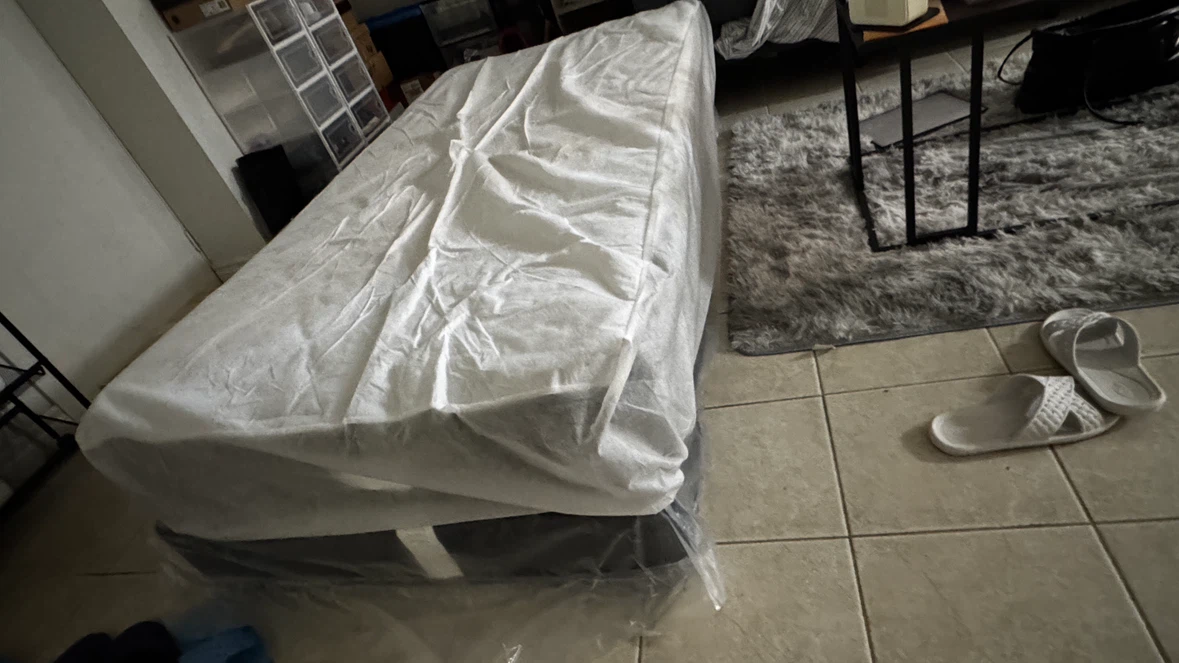 Boxspring in plastic packaging with Twin size mattress