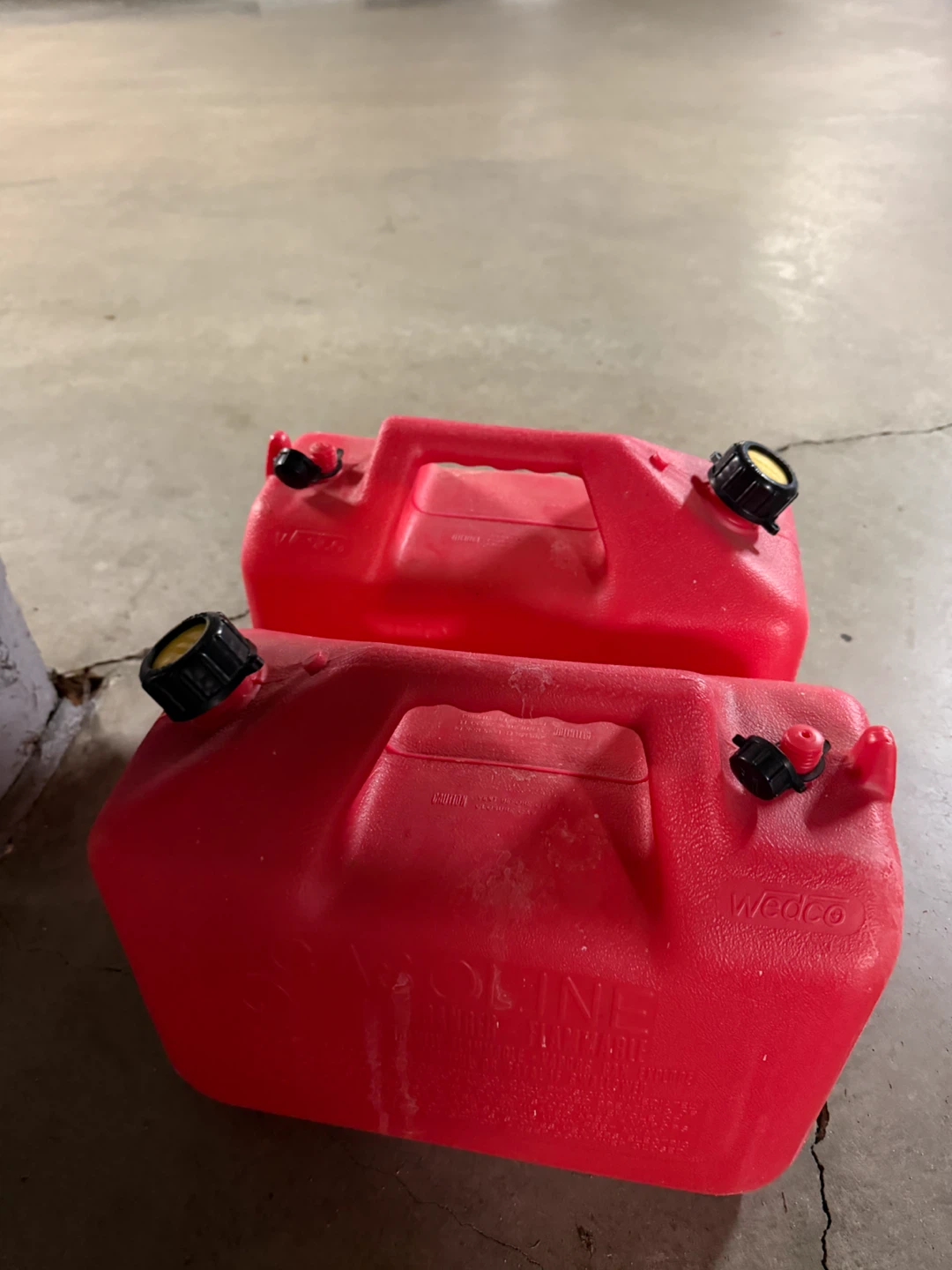 Two Wedco red gasoline cans