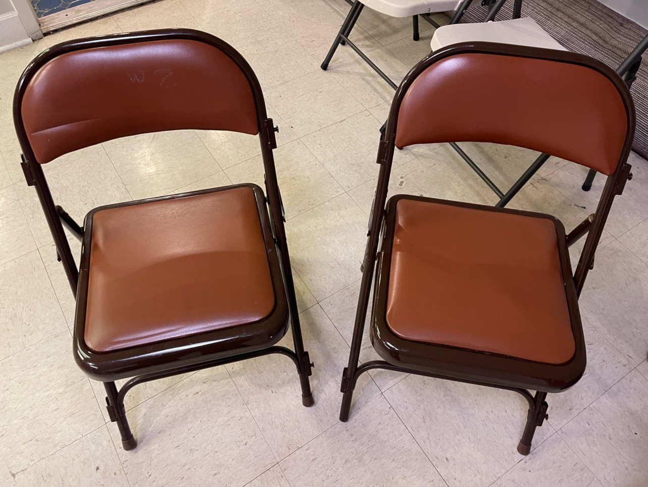 Two Brown Vinyl Folding Chairs