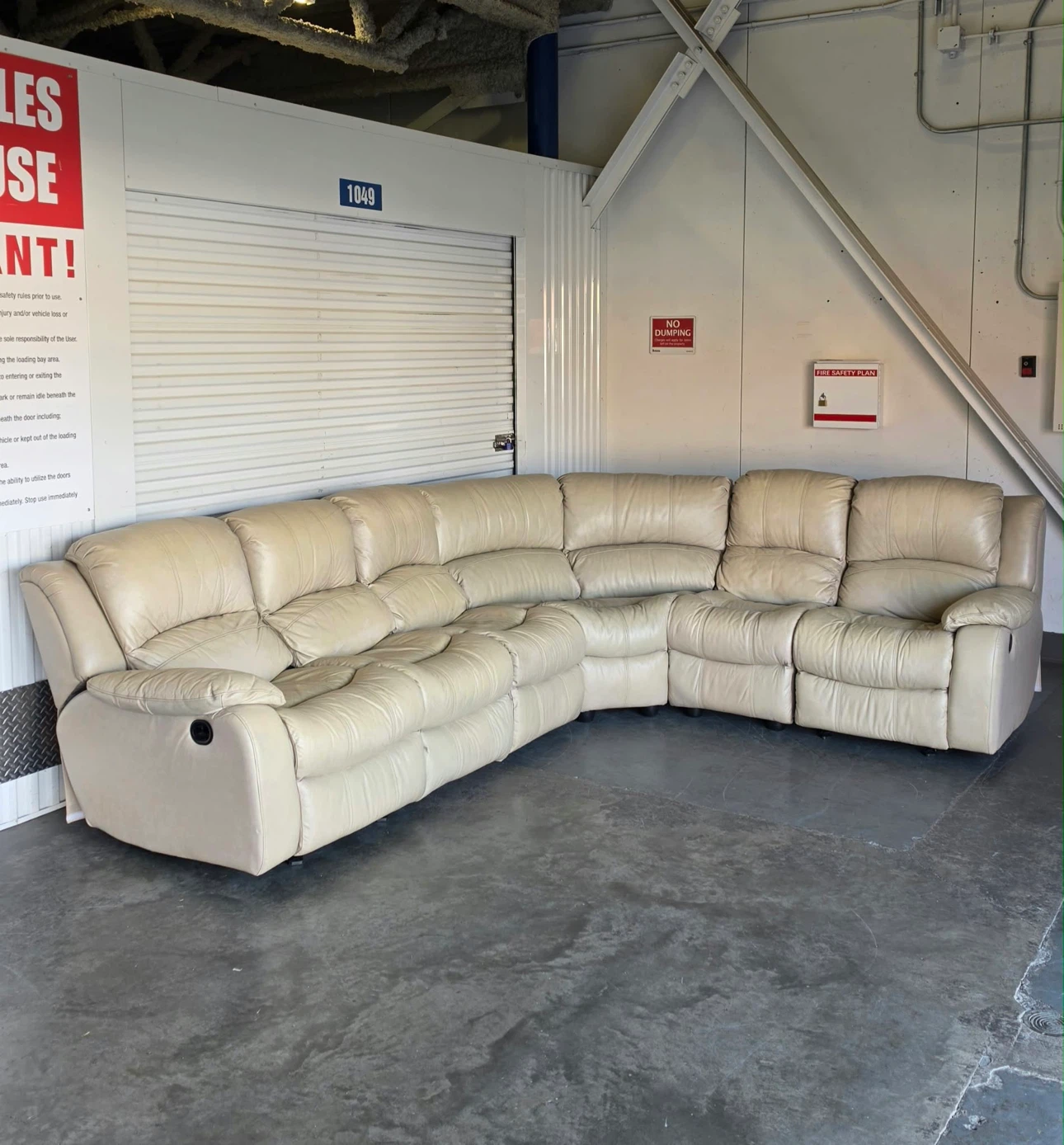 Spacious sectional sofa is upholstered in cream leather.