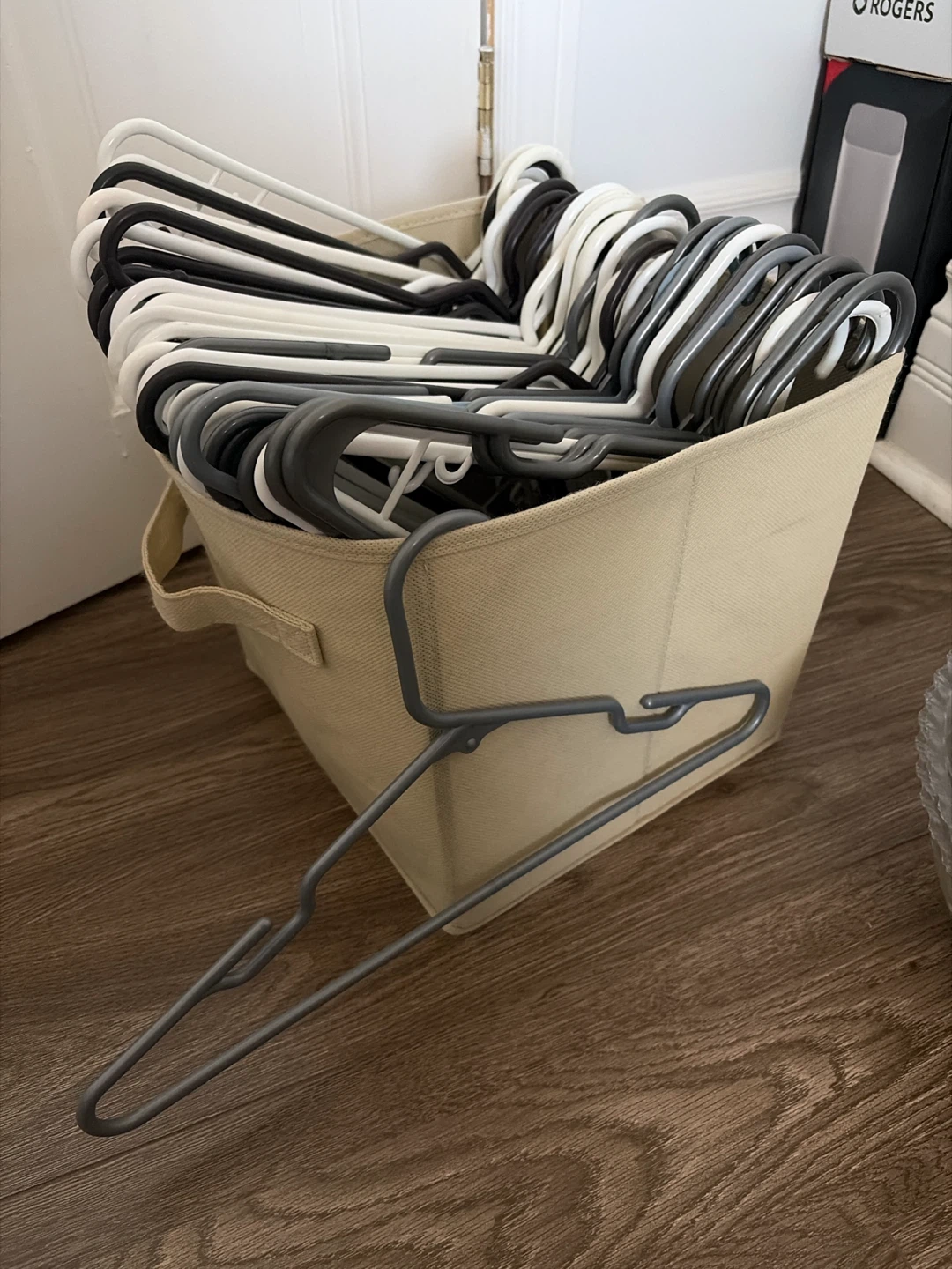 Assorted Plastic Clothes Hangers in Storage Bin