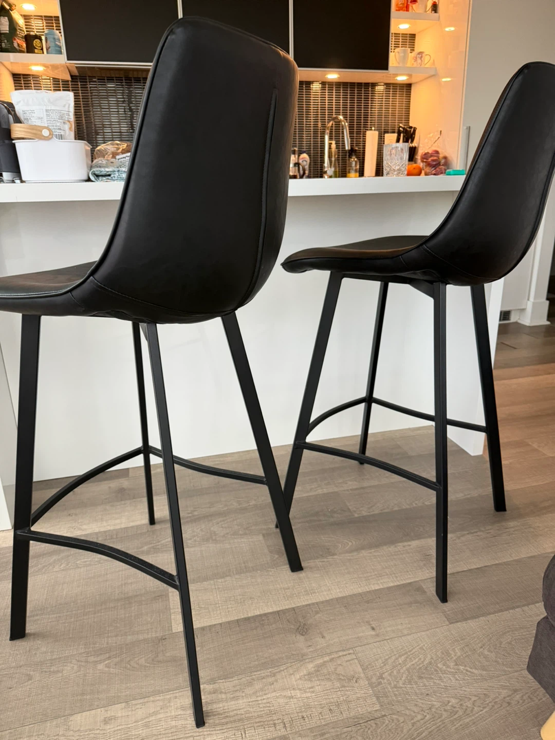 Two black faux leather bar stools