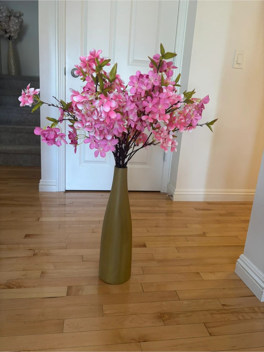 Tall olive green vase with artificial flowers