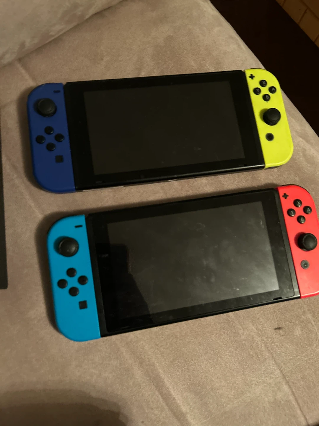 Two Nintendo Switch consoles with dock and cables
