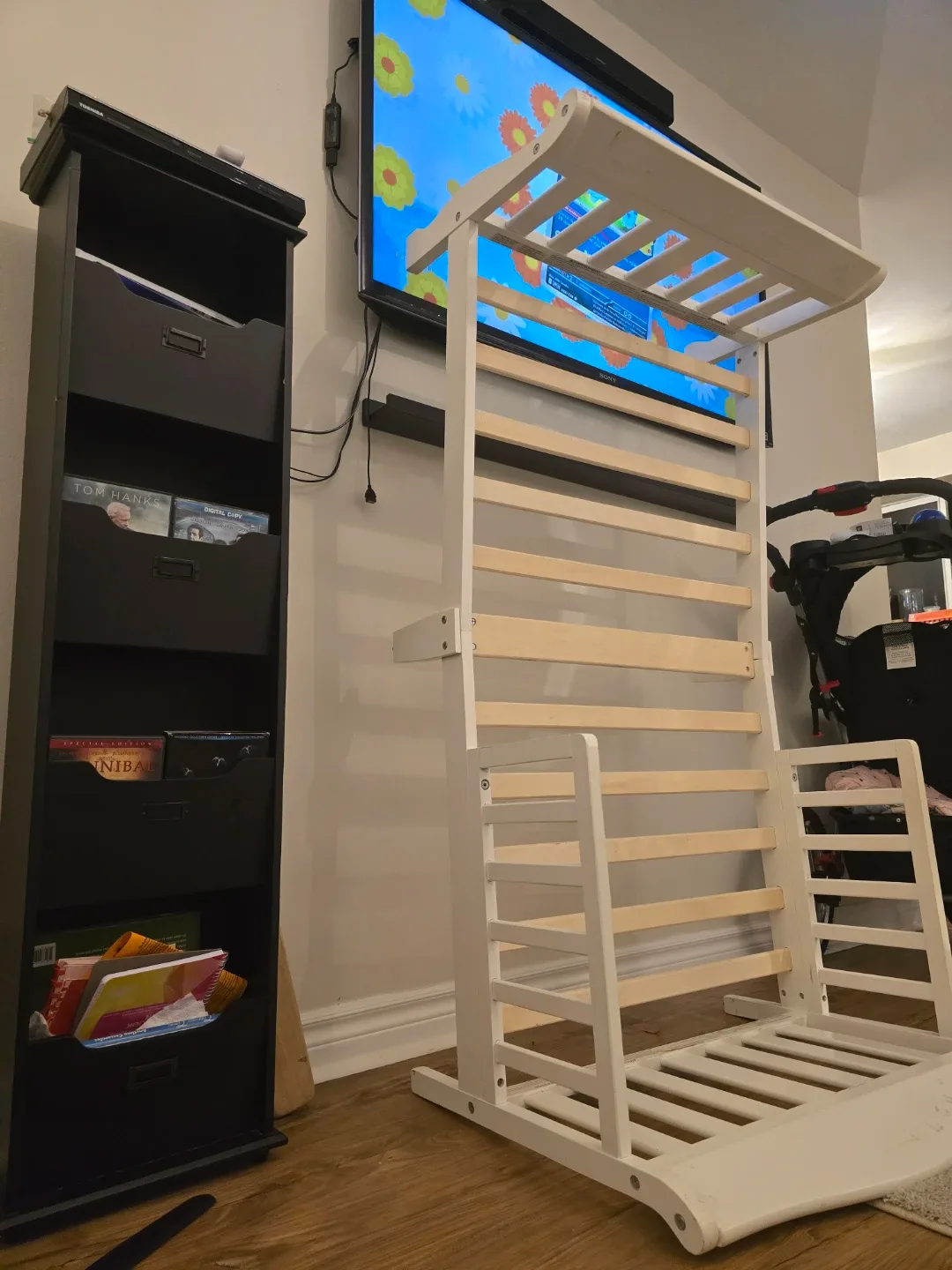 White bed frame, Toshiba DVD player , and black shelf.