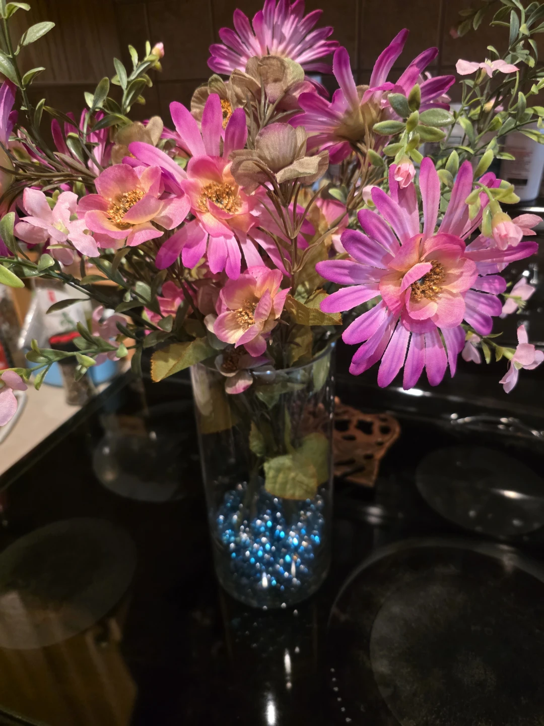Artificial pink flower arrangement in glass vase