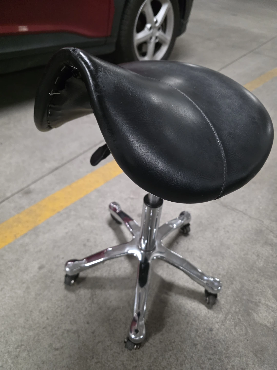 Black rolling saddle stool