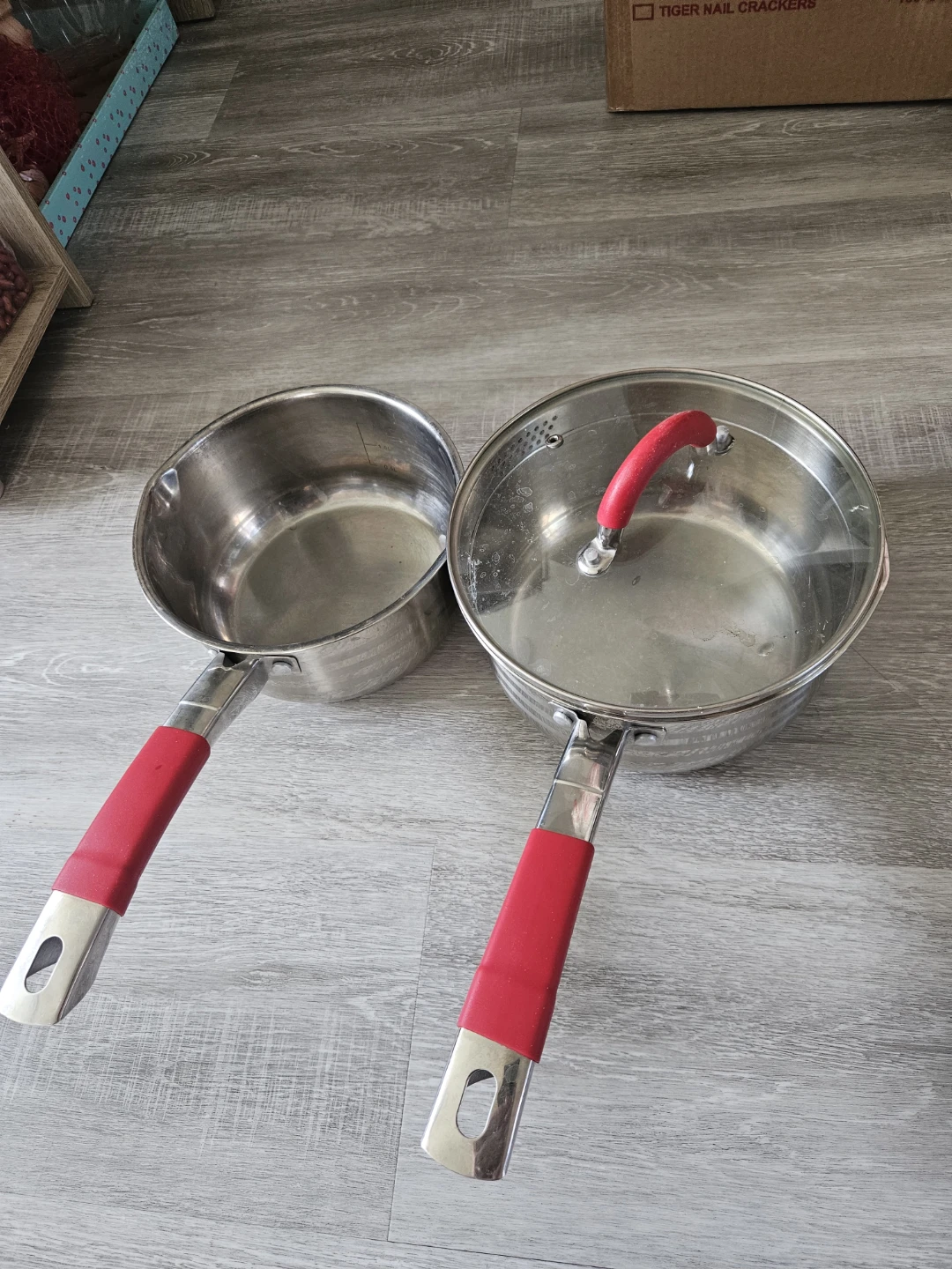 Two Stainless Steel Saucepans with Red Handles
