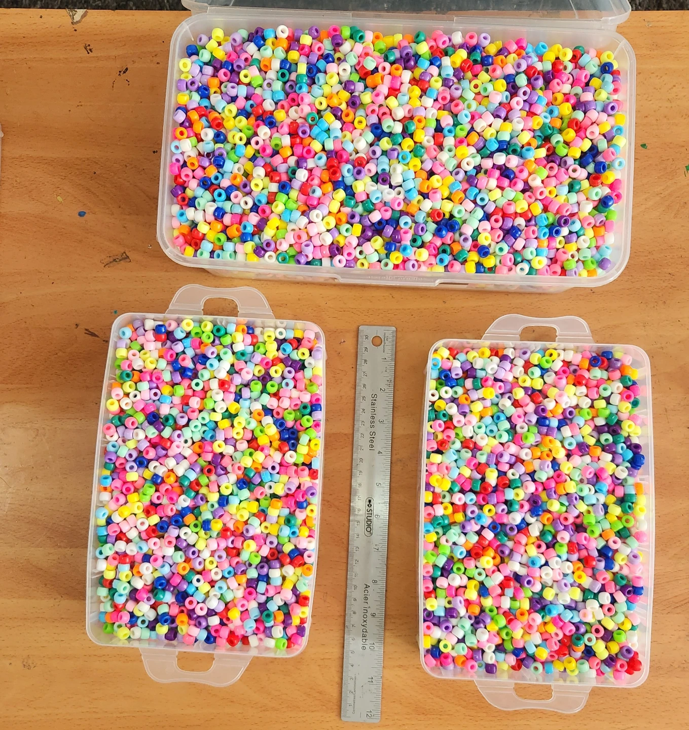 Assorted colourful craft pony beads in storage containers