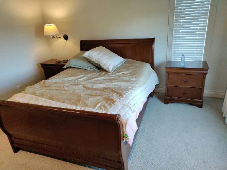 Solid wood sleigh bed frame and two matching nightstands.