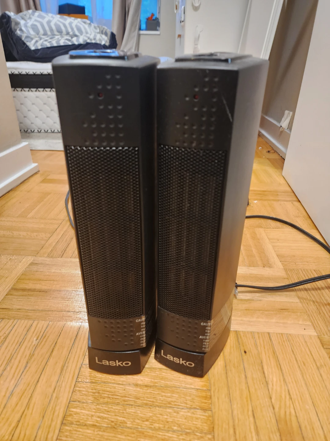 Two Lasko black tower heaters