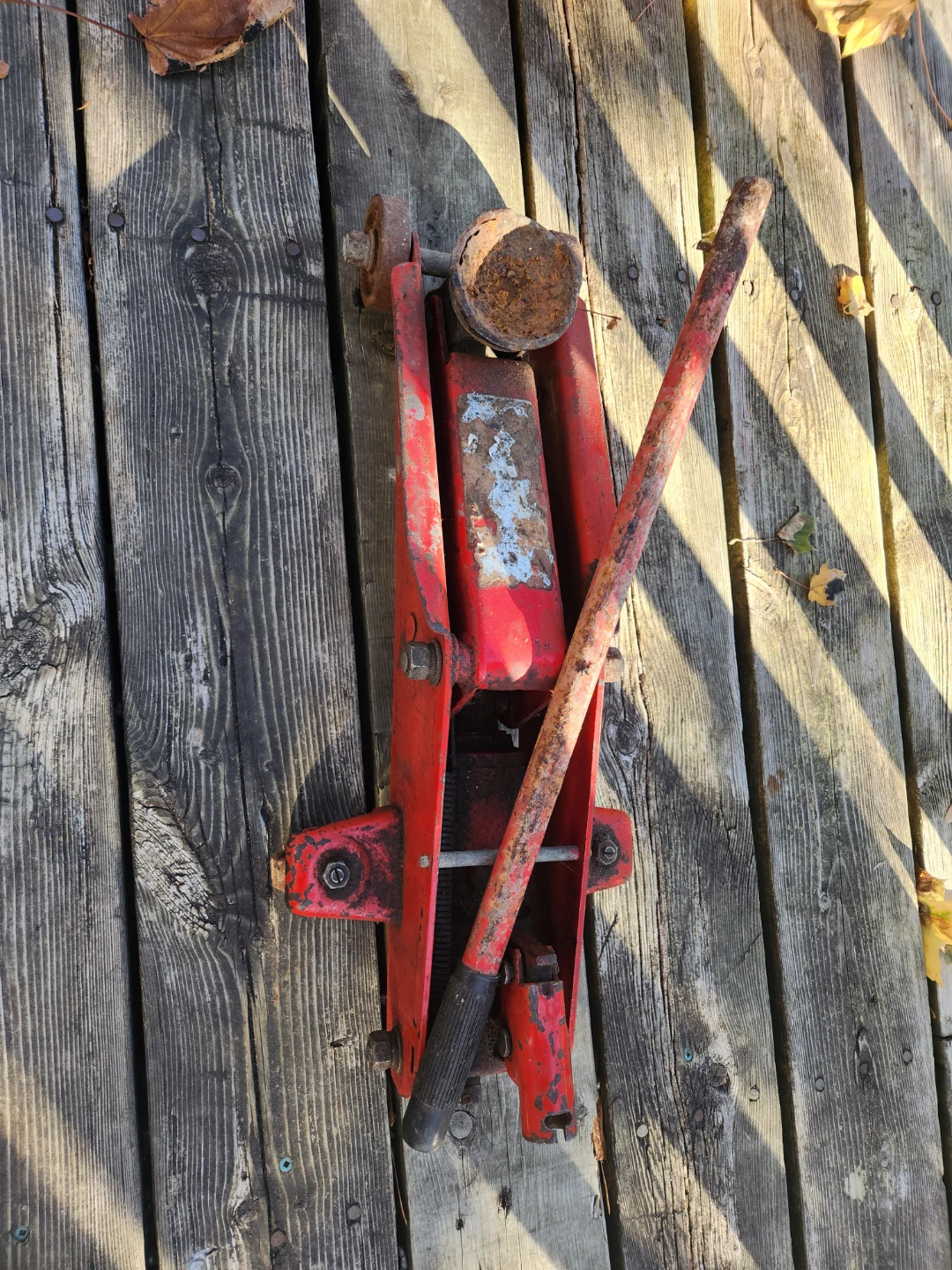 Red hydraulic floor jack. As is rusted