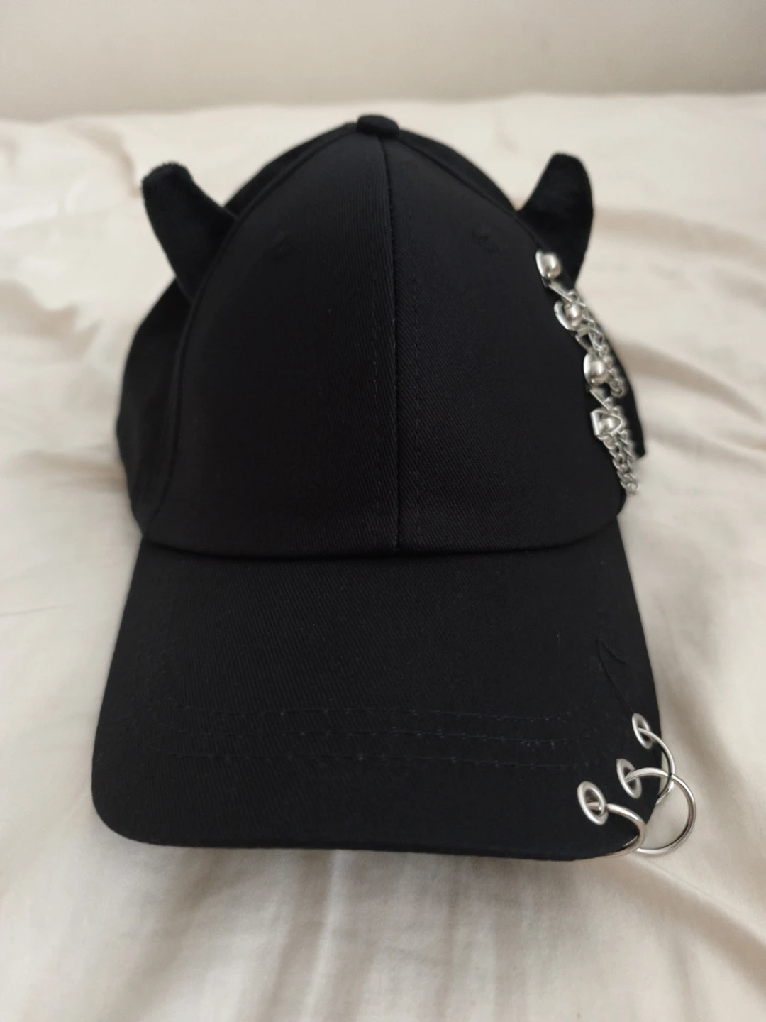 Black cap with soft horns and silver chain details