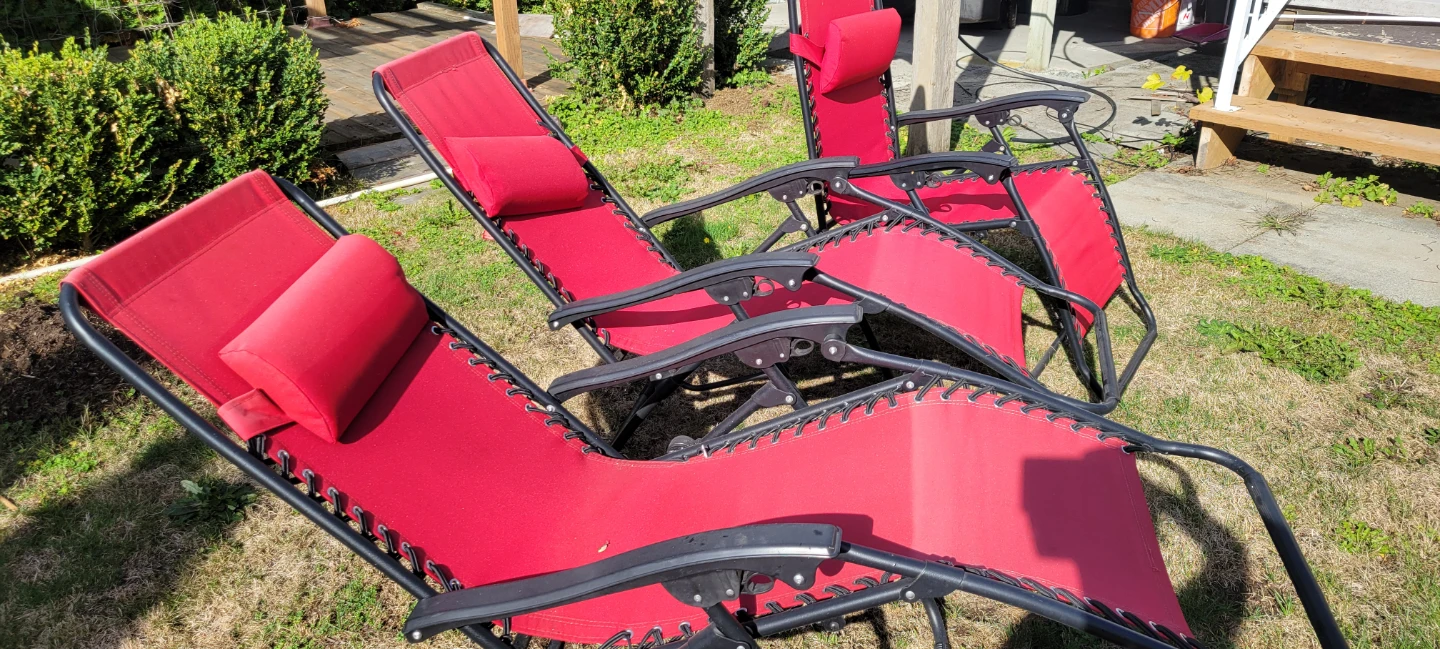 Three red zero gravity lounge chairs