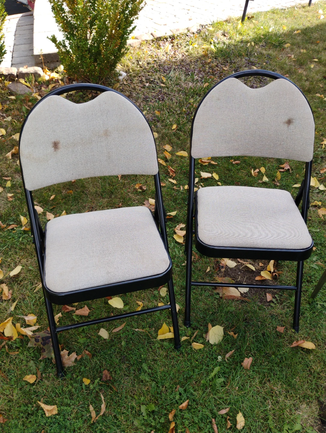 Two beige metal folding chairs