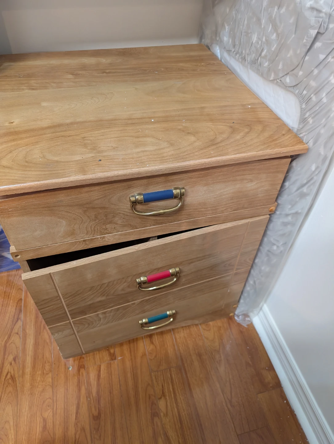 Wooden bedside table with three drawers
