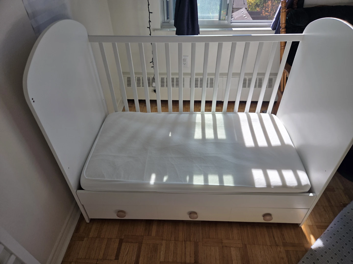 White baby crib with mattress