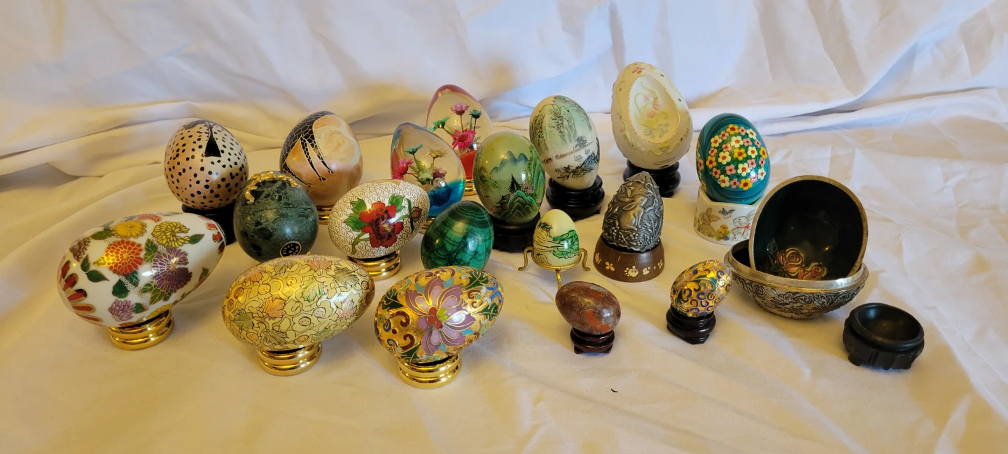 Collection of various decorative eggs and stands
