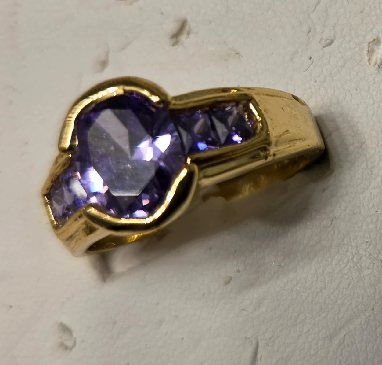Gold plate ring wih faux amethyst in  center and side channels