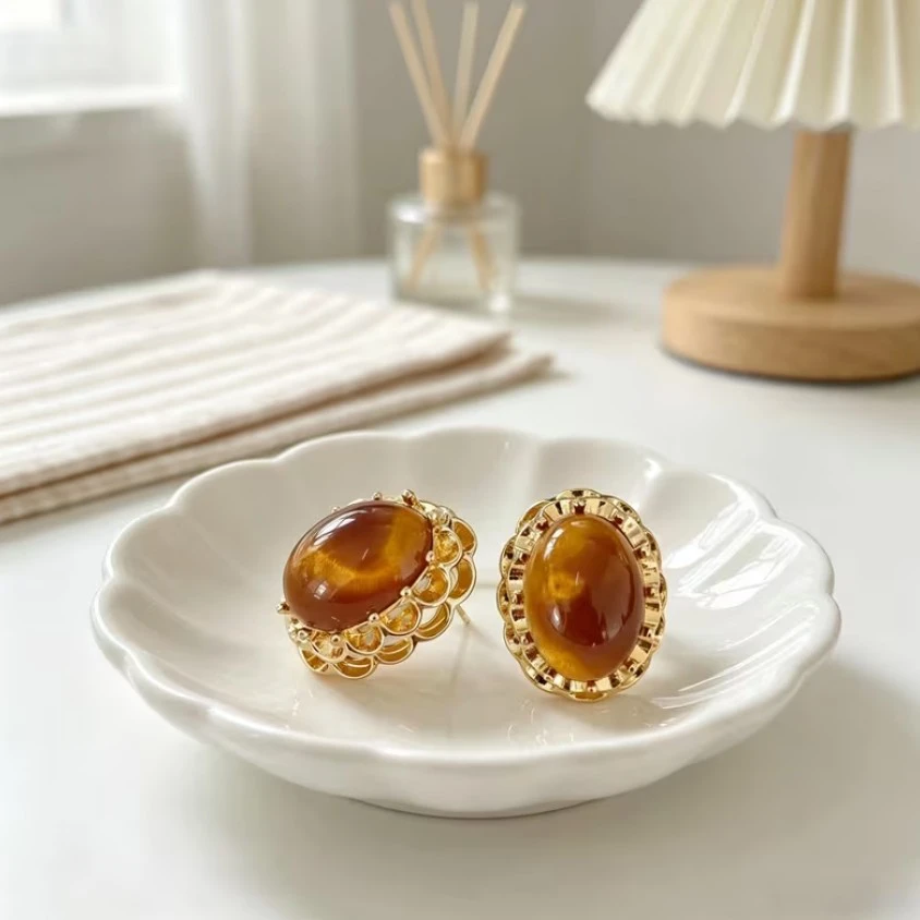 Amber-colored oval stud earrings with gold-tone setting
