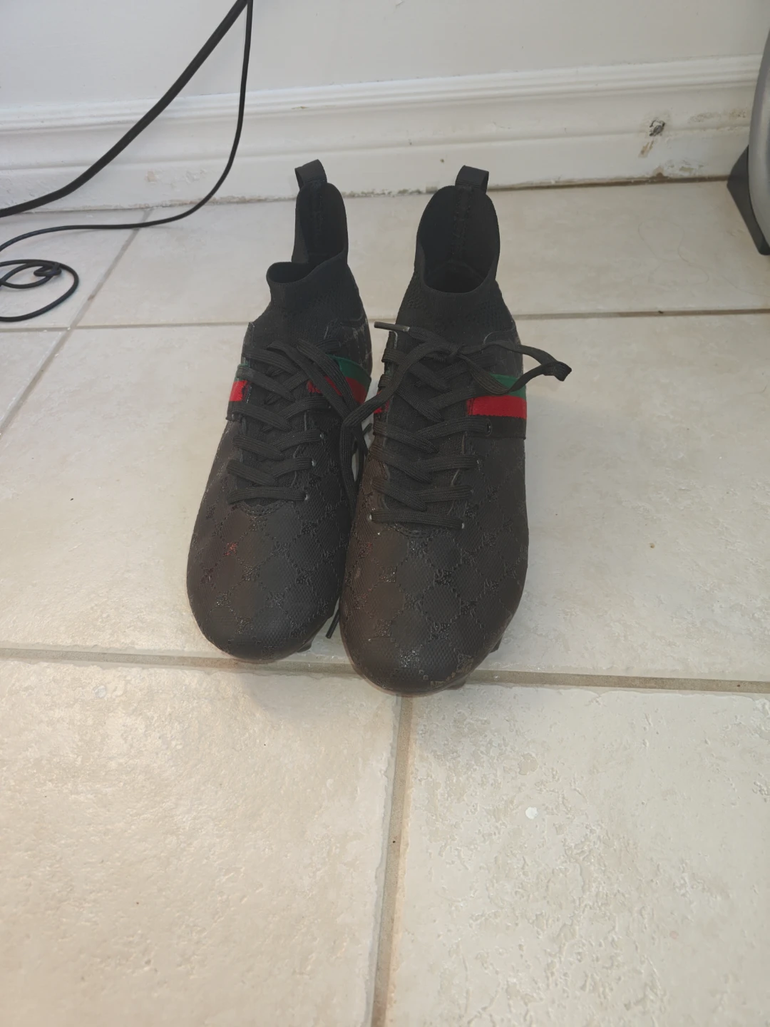 Black soccer cleats with green and red accents