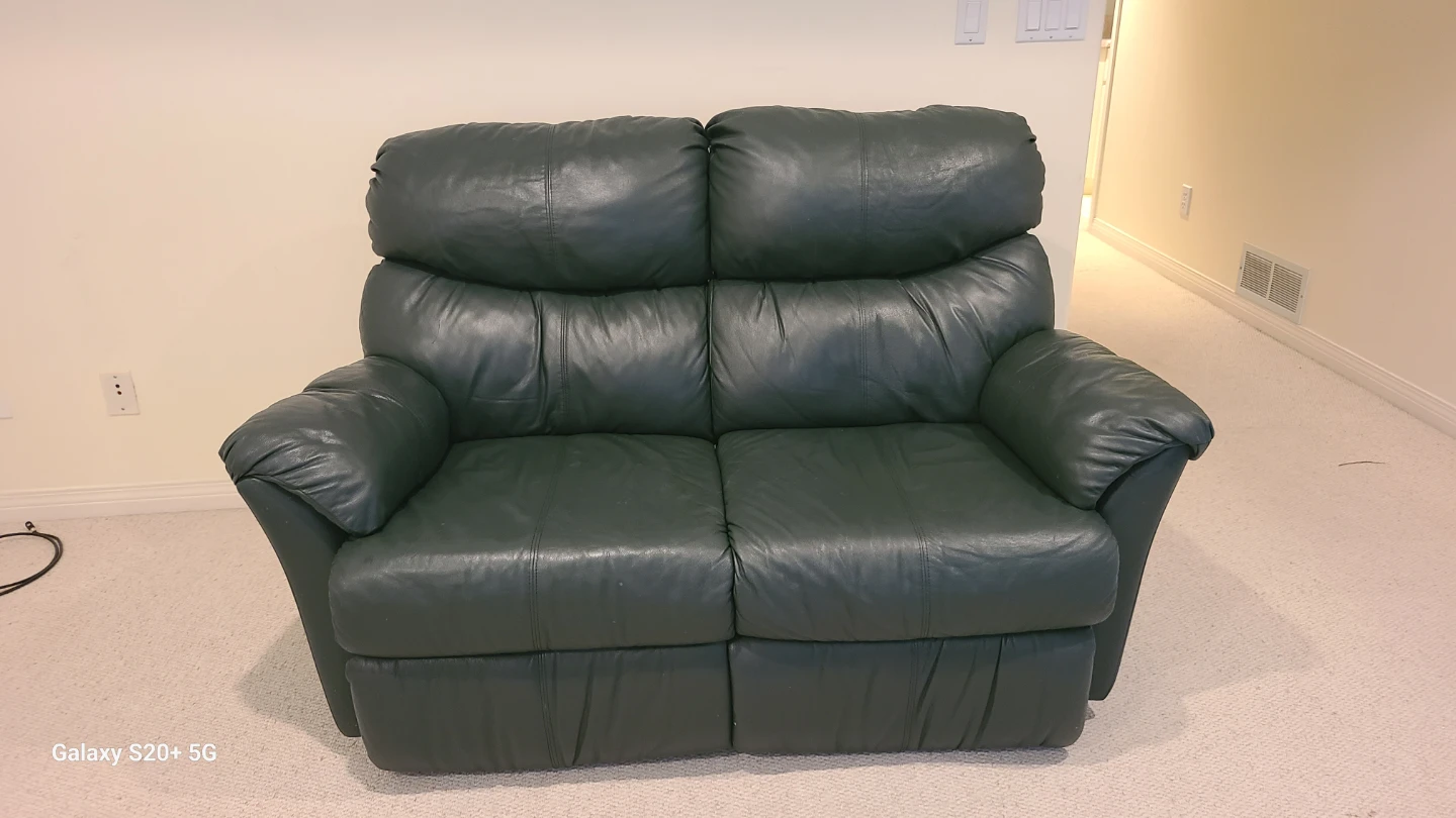 Dark green leather reclining sofa and loveseat