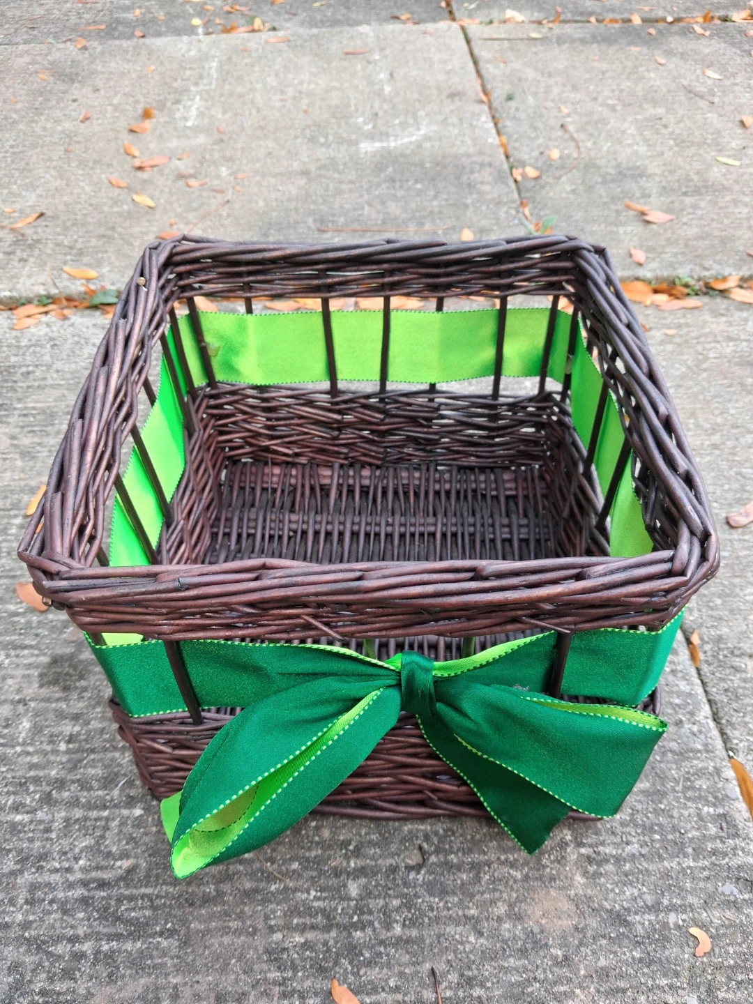 Clean woven brown wicker basket with green ribbon